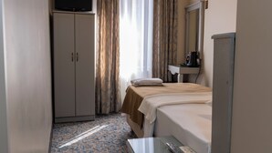 A hotel room with a bed, a desk, a television, a wardrobe, a mirror, and an air conditioning unit. - Hotel Umit 2 (İstanbul)
