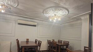 A dining area with a high ceiling, decorative moldings, and a chandelier. - Hotel Umit 2 (İstanbul)