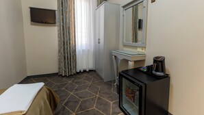 A hotel room with a bed, a small desk, a refrigerator, a television, and a mirror. - Hotel Umit 2 (İstanbul)