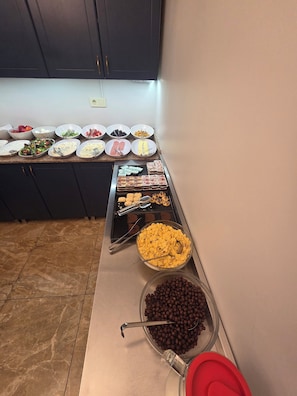 Un buffet proposant une variété de plats et d’ustensiles.