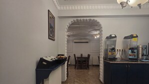 A hotel lobby with a marble floor, a reception desk, a dining area, and a kitchen area with coffee machines. - Hotel Umit 2 (İstanbul)