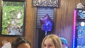 Two people seated at a table with a checkered tablecloth, a framed picture on the wall, and a neon sign in the background. - Fantastic building with AC in lovely Ashland (Ashland)