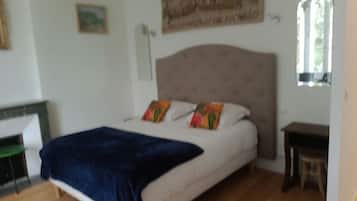 Un dormitorio con cama, ventana y un cuadro en la pared.