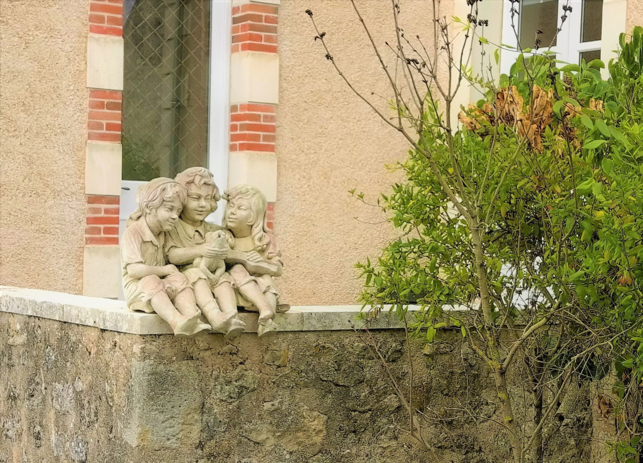 A stone bench with a sculpture of three figures.