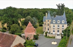 Ein weitläufiges Anwesen mit einem markanten Turm und einem Hauptgebäude mit zahlreichen Fenstern und einem steilen Dach.