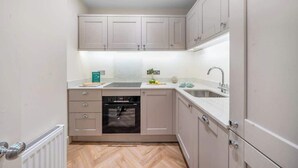 A modern kitchen with built-in appliances, a countertop, and a sink. - Prime Location! 1-Bed Flat Nr Attractions - VAT Q (Bath)