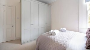 A bedroom with a bed, a wardrobe, and a window. - Prime Location! 1-Bed Flat Nr Attractions - VAT Q (Bath)