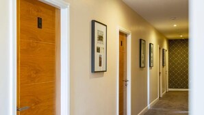 A hallway with wooden doors and framed pictures on the walls.