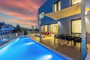 A modern building with a swimming pool, outdoor seating, and a view of the sky. - Modern House with a Pool in Crikvenica (Crikvenica)