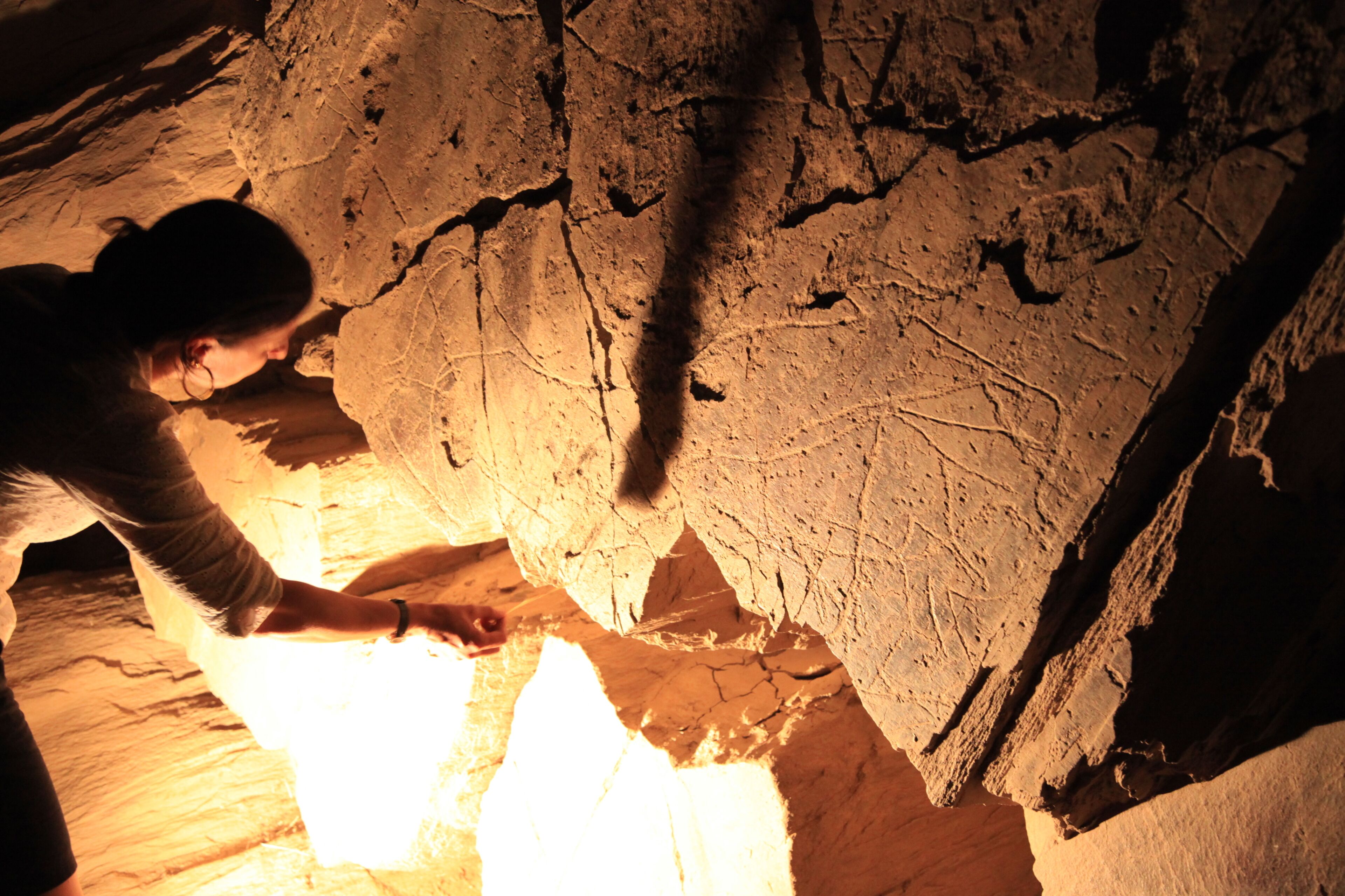 Une personne qui examine la paroi d’une grotte.
