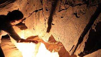 Une personne qui examine la paroi d’une grotte.