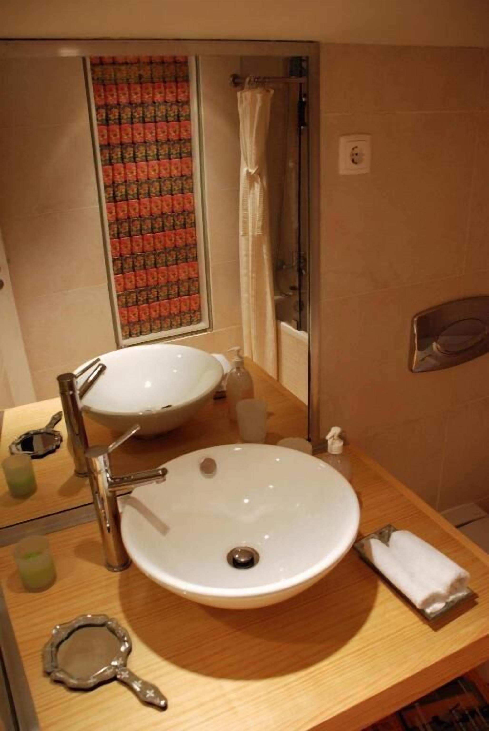 A bathroom with a double sink, a shower, and a towel rack.