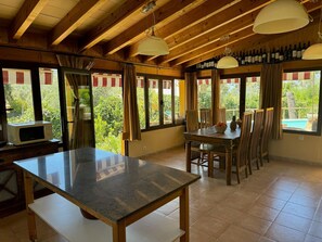 Een eetgedeelte met een tafel, stoelen en uitzicht op de omgeving.