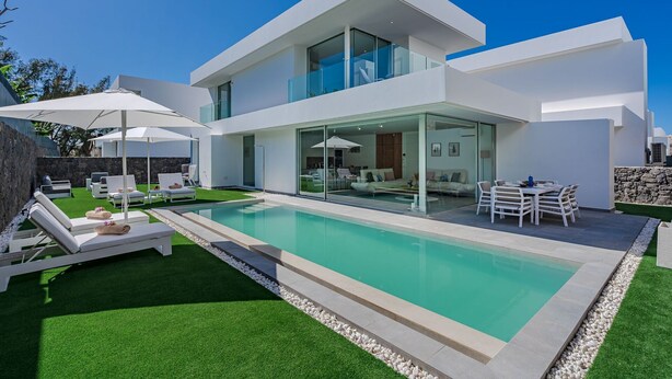 A modern two-story house with a swimming pool, outdoor seating, and a glass-enclosed patio. - Standard Villa 2 - Casangular by Upper (Adeje)