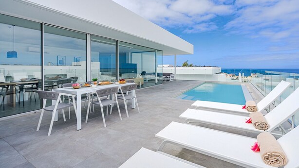 A modern outdoor dining area with a pool and lounge chairs. - Standard Villa 6 - Casangular by Upper (Adeje)