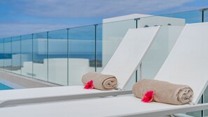 Two white lounge chairs with towels and pink flowers, overlooking a pool and a clear sky. - Standard Villa 6 - Casangular by Upper (Adeje)