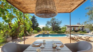A wooden table set for dining with a pool and lounge chairs in the background. - 5 minutes from beaches Room with shared pool in Salento, Puglia (Salve)