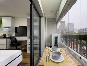 A modern apartment with a kitchen, dining area, and a balcony with a city view. - Zip Brooklin NR (São Paulo)