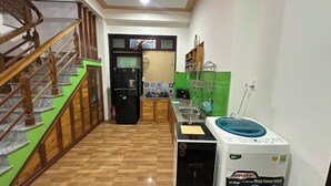 Une cuisine équipée d’un réfrigérateur, d’un lave-linge et d’un mur végétal.