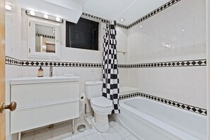A bathroom with a toilet, sink, and bathtub. - Heritage Mansion 1BR unit in heart of MTL (Montreal)