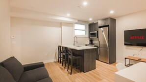 Eine moderne Wohnung mit Küche, Essbereich und Wohnzimmer mit Sofa.