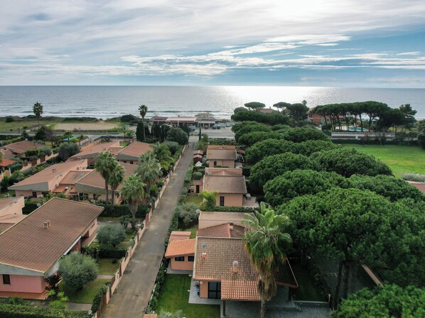 Un barrio residencial con casas, una calle y vistas al mar.