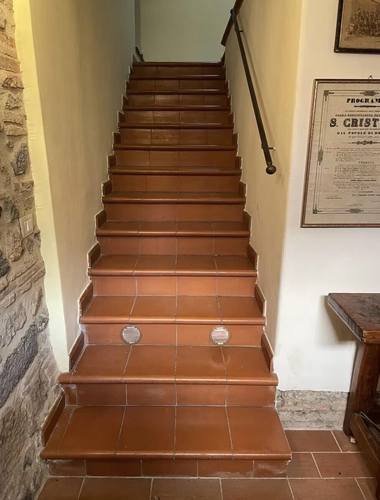A staircase with wooden steps and metal handrails, leading to a higher floor.