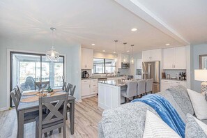 A modern kitchen with white cabinetry, a central island, and pendant lighting. - Ocean Pines Oasis | Firepit, 4BR & 10 Min to Beach (Ocean Pines)