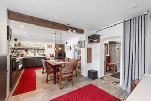 Una cocina moderna con comedor, vigas de madera y un proyector.