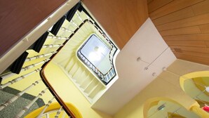 A multi-level interior with a central staircase, a skylight, and a modern design. - Hotel Reichshof (Schwerte)