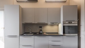 Et moderne køkken med indbyggede apparater, en bordplade og en stol.