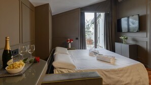 Et hotelværelse med en seng, et fjernsyn, et vindue og et bord med en flaske og glas.