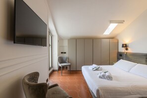 A hotel room with a bed, a chair, a TV, and a wardrobe. - PALERMO, 18 - Brera from above: Two-bedroom apartment with a terrace (Milan)