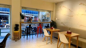 A cafe interior with a counter, seating area, and a view of the street.