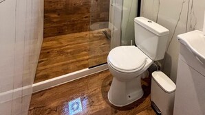 A bathroom with a glass-enclosed shower, a toilet, and a bidet. - Double room on ground floor (Syvota)