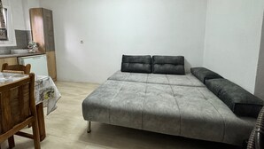 A small, compact room with a bed, a desk, and a kitchenette. - Double room on ground floor (Syvota)