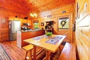 A wooden cabin interior with a kitchen, dining area, and a fireplace. - Douglas Lake Cabin Retreat・Beautiful Views・Hot Tub (Sevierville)