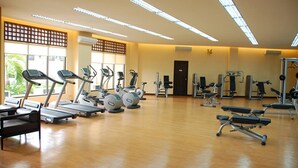Un gimnasio con cintas de correr, elípticas y máquinas de pesas.