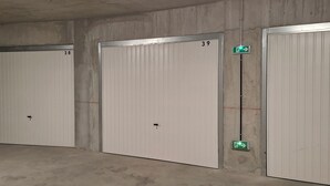 Trois portes blanches portant les numéros 38, 39 et 40, ainsi qu’un panneau vert indiquant la sortie de secours.