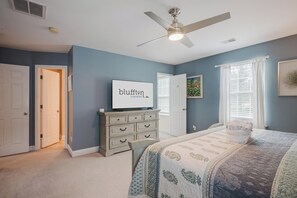A bedroom with a bed, a dresser, a ceiling fan, a television, and a window with blinds. - Dogs Welcome! Adorable 3-bedroom Coastal Home in Historic Old Town Bluffton (Bluffton)
