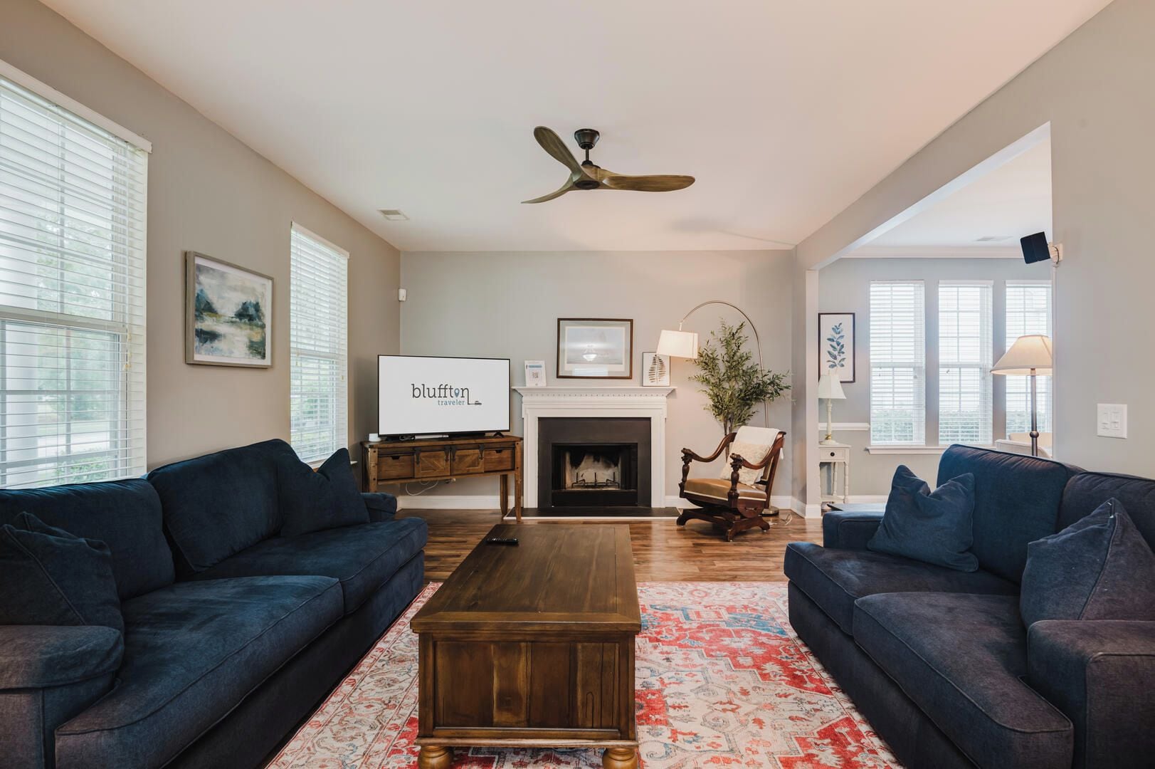 A spacious living room with two sofas, a coffee table, a fireplace, and a television.