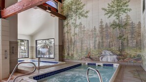 A spa area with a hot tub, wooden beams, and a forest mural on the wall. - Beautiful 2BR/2BA condo in Keystone, offering a tranquil mountain retreat (Keystone)