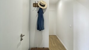 A hallway with a wooden floor, a wicker trunk, a hat, and a jacket hanging on a wall-mounted rack. - WHOLE APARTMENT WITH PARK AND SEA VIEW TROUVILLE SUR MER. (Trouville-sur-Mer)