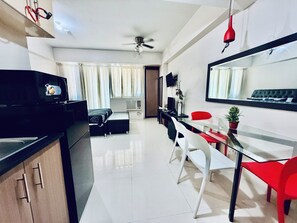 Une cuisine moderne équipée d’un four à micro-ondes, d’une table à manger avec des chaises, d’un ventilateur de plafond et d’un grand miroir.