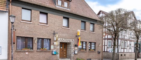 A traditional brick building with a sign reading 'GASTHAUS' and a wooden door.