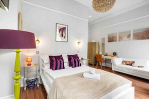 Ein Hotelzimmer mit einem Bett, einem Schreibtisch, einem Sessel und einer Couch.