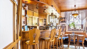 Eine Bar mit hölzernen Barhocker, einer Holztresen und hängenden Leuchten.