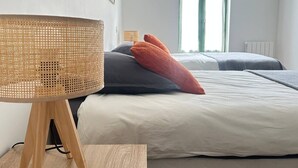 Una camera da letto con un letto, una lampada da terra e una finestra.