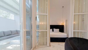 Ein modernes Hotelzimmer mit Bett, einer Couch und einem Sessel.