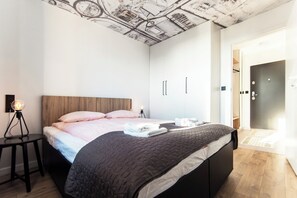 A bedroom with a bed, bedside table, and a ceiling with a map design.